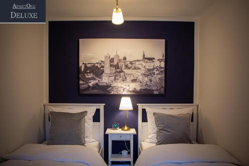 two beds in a bedroom with a picture on the wall at ApartOne Altstadt-Hotel in Bautzen