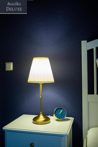 a table with a lamp and a clock on it at ApartOne Altstadt-Hotel in Bautzen