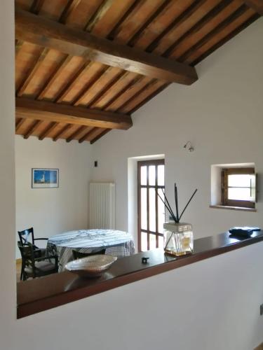 a dining room with a table in a room with wooden ceilings at Relais Poggio al Vento in Pomarance