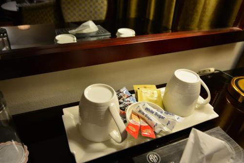 two white mugs sitting on a table in a hotel room at Rakeen Hotel in Amman