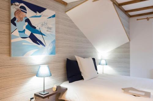 une chambre avec un lit et un tableau au mur dans l'établissement Echo des montagnes, à Chalmazel Jeansagniere