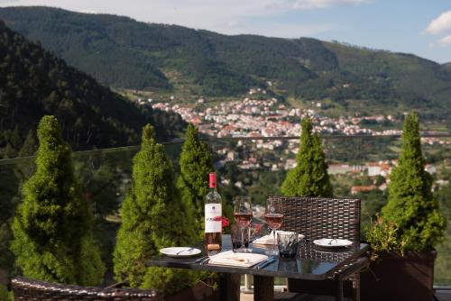 a table with a bottle of wine and glasses at Vila Gale Serra da Estrela in Manteigas