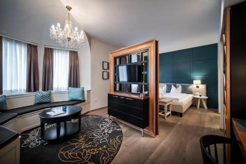 a hotel room with a living room with a bedroom at Post Hotel - Tradition & Lifestyle Adults Only in San Candido