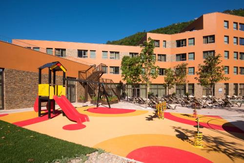 a playground in front of a large building at Vila Gale Serra da Estrela in Manteigas