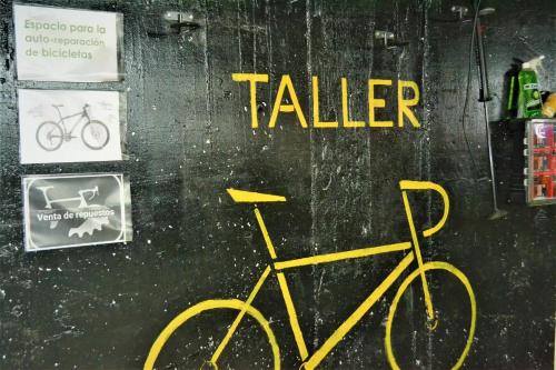 a yellow bike parked next to a wall with the word taller at Gran Hotel Toledo in Onda