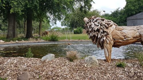 a statue of a bird standing in front of a pond at B&B Johannes-Hoeve in Baarlo