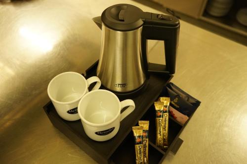 a coffee maker and two cups on a shelf at Landkomforthotel Panorama & Restaurant Bella Vista in Garmisch-Partenkirchen