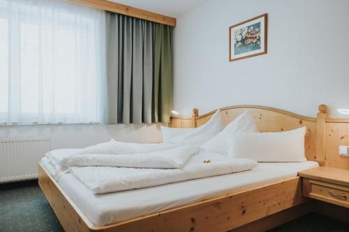 a bedroom with a wooden bed with white pillows at Hotel Silberfux in Sankt Veit im Pongau