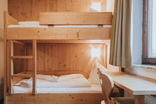 a wooden bunk bed in a room with a desk at Hotel Silberfux in Sankt Veit im Pongau