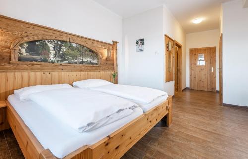 a bedroom with a large bed with a wooden headboard at Pension Feichthub in Nussbach