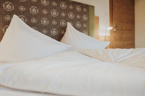 a bedroom with white pillows on a bed at Hotel Silberfux in Sankt Veit im Pongau
