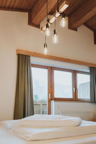 a bedroom with a bed and two windows at Hotel Silberfux in Sankt Veit im Pongau