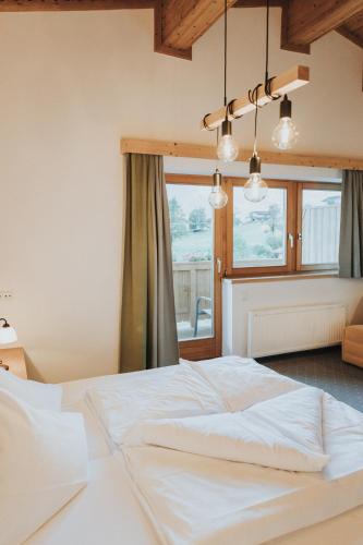 a bedroom with a large white bed in front of a window at Hotel Silberfux in Sankt Veit im Pongau