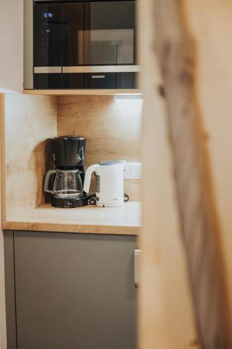 a kitchen counter with a coffee maker and a toaster at Hotel Silberfux in Sankt Veit im Pongau