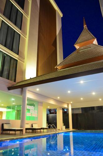 a hotel with a swimming pool at night at Tevan Jomtien Pattaya in Jomtien Beach