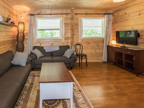 ein Wohnzimmer mit einem Sofa und einem TV in der Unterkunft Holiday Home Kuusela by Interhome in Somerniemi