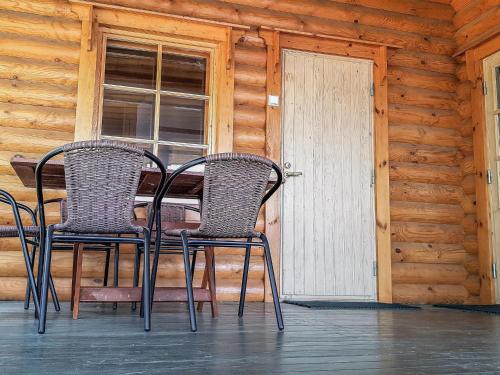 2 sillas y una mesa en el porche de una cabaña en Holiday Home Männikkö by Interhome en Kammola