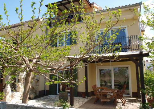 een huis met een veranda en een patio bij Apartments Batistić in Supetarska Draga