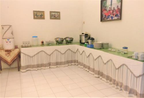 KlatenにあるHotel Perdanaのキッチン(テーブル、カウンタートップ付)