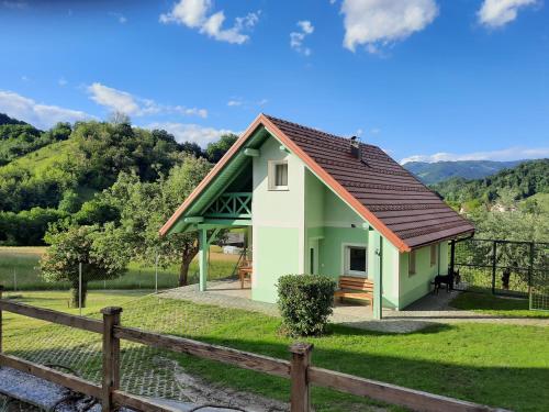 una pequeña casa verde con techo marrón en Holiday Home Neokrnjena Narava, en Sevnica