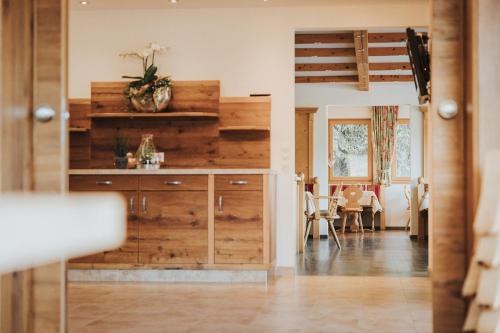 a kitchen with wooden cabinets and a dining room at Hotel Silberfux in Sankt Veit im Pongau