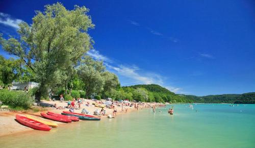 a group of people on a beach with boats in the water at CHALET LE HERISSON in Saint-Laurent-du-Jura