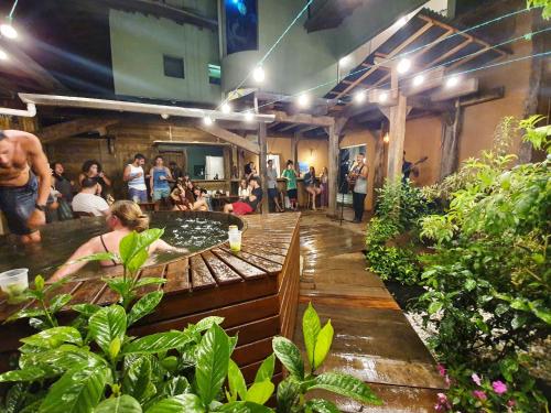 um grupo de pessoas sentadas em torno de um bar em um jardim em Green Haven Hostel em Ubatuba
