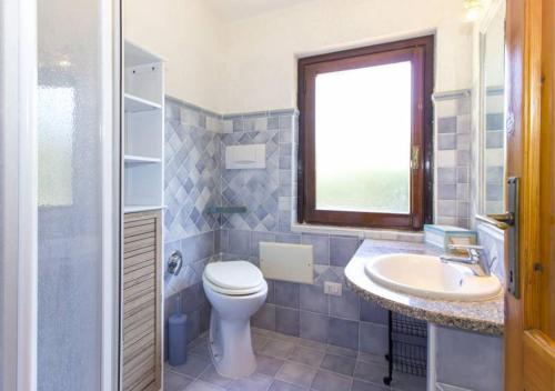 bagno con servizi igienici, lavandino e finestra di Villetta Delfino a Rena Majore