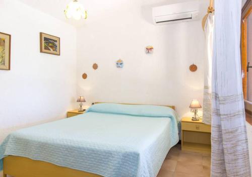 ein weißes Schlafzimmer mit einem Bett und zwei Nachttischen in der Unterkunft Villetta Delfino in Rena Majore