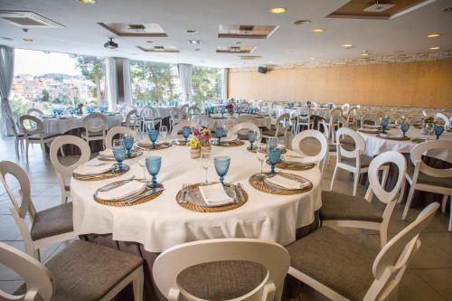 un salón de banquetes con mesas y sillas blancas en Savoy, en Alcoy