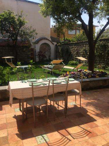 a table and chairs in a yard with a garden at Maison De Lucia in Meta