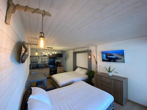 a small bedroom with two beds and a kitchen at Atlantic Selection - Le studio 48 in Capbreton