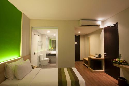 Tempat tidur dalam kamar di Grand Whiz Hotel Nusa Dua Bali