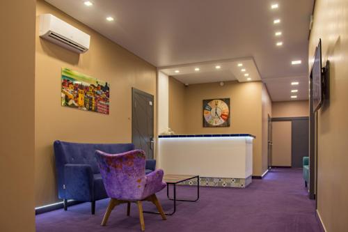 Odessa的住宿－Horizon Hotel，一间设有紫色椅子和桌子的等候室