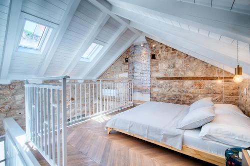 1 dormitorio con cama y pared de ladrillo en Studio Apartment Vicencina en Vis