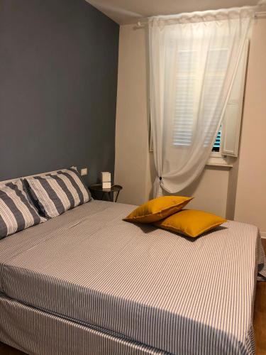 a bedroom with a bed with two pillows and a window at L'Iris B&B in Terrazza in Lucca