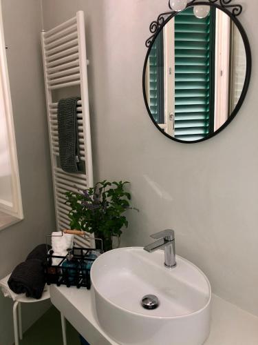 a bathroom with a white sink and a mirror at L'Iris B&B in Terrazza in Lucca