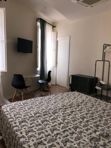 a bedroom with a bed and a table and chairs at L'Iris B&B in Terrazza in Lucca