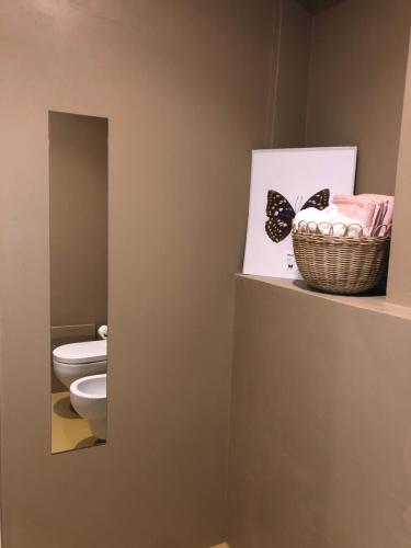 a bathroom with a toilet and a picture of a butterfly at L'Iris B&B in Terrazza in Lucca