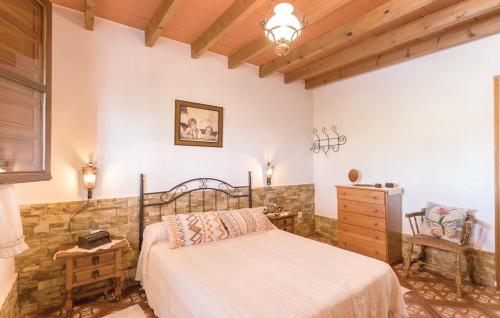 a bedroom with a bed and a stone wall at Casa Lola in Sayalonga