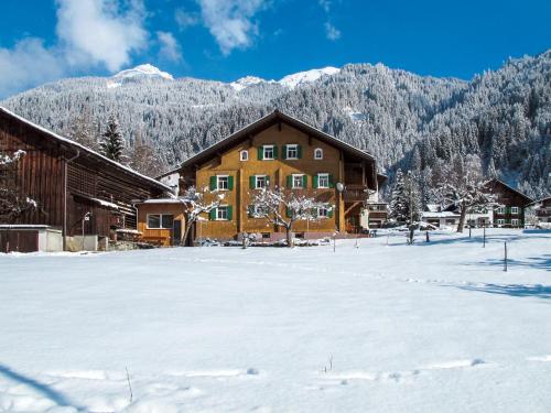 een blokhut in de sneeuw met bergen op de achtergrond bij Holiday Home Haus Hermann - GOP225 by Interhome in Sankt Gallenkirch