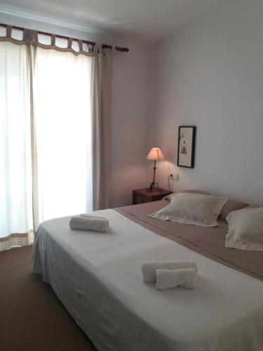 1 dormitorio con 1 cama grande y 2 toallas. en OJOS DE MAR views of Es Vedrá en Cala Vadella