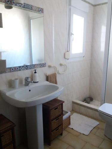 uma casa de banho com um lavatório, um espelho e uma banheira em OJOS DE MAR views of Es Vedrá em Cala Vadella