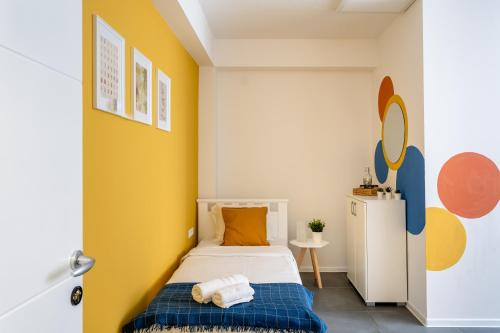 een kleine slaapkamer met een bed en een gele muur bij Kostovski Rooms-near E75 to Greece in Veles