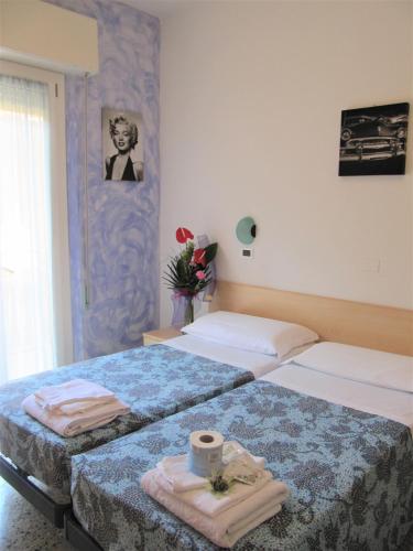 zwei Betten in einem Hotelzimmer mit Handtüchern darauf in der Unterkunft Hotel Villa Elia in Rimini