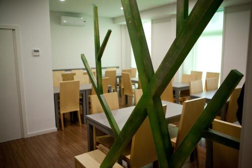 a room with a table and chairs and a plant at Hotel Comércio in Resende