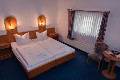 a bedroom with a bed and a table and a chair at Börse Coswig in Coswig