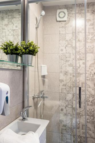 a bathroom with a sink and a shower with potted plants at Kostovski Rooms-near E75 to Greece in Veles