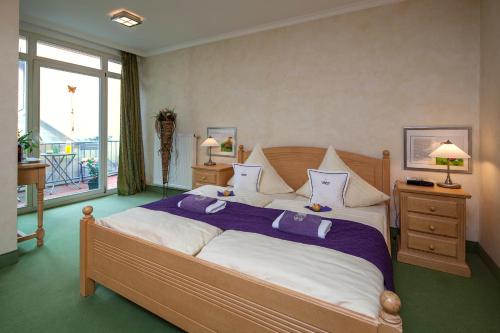 a bedroom with a large bed with purple and white pillows at Gästehaus am Markt - Leisnig in Leisnig