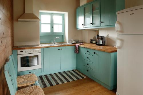 a kitchen with blue cabinets and a white refrigerator at Rizes in Psárion
